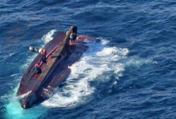 해양경찰이 지난 9일 통영 해상에서 전복된 어선에 올라 구조 작업을 하고 있다. 통영해양경찰서 제공