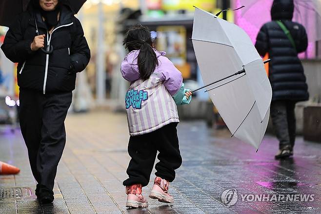 바람에 날리는 우산 잡는 어린이 (서울=연합뉴스) 신현우 기자 = 전국 곳곳 비나 눈이 내린 21일 오후 서울 중구 명동거리에서 한 어린이가 바람에 날리는 우산을 잡고 있다. 2024.2.21 nowwego@yna.co.kr