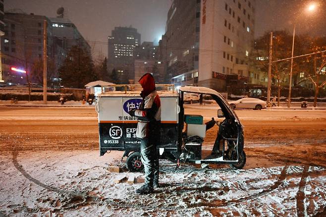 중국 베이징에서 한 물류 직원이 택배를 배송하고 있다. (사진=AFP)