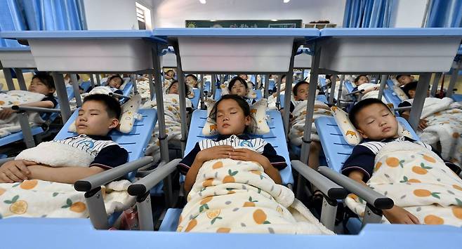 2022년 6월 13일 중국 허베이(河北)성 한단(邯鄲)시 동문외초등학교 학생들이 변신 책걸상을 침상으로 바꾸고 잠을 자고 있다./허베이방송