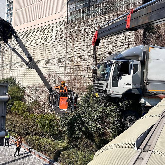 13일 오전 9시50분쯤 부산 동구 좌천동 고가도로 위에서 수정터널서 부산항 5부두 방향으로 달리던 6.5t트럭이 난간을 뚫고 나가 차체 앞부분이 공중에 매달려 있다. /부산소방재난본부