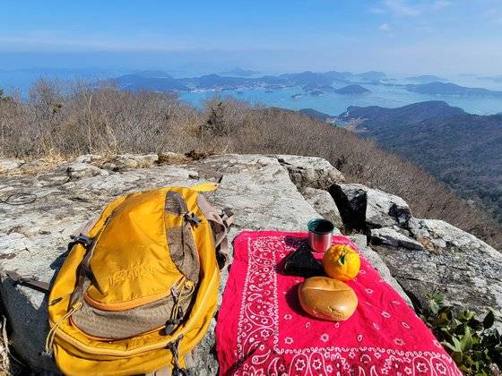 백운산 능선에는 평평한 바위들이 많아 발길 멈춘 곳이 전망대다. 바위를 밥상 삼아 소박한 점심을 즐겼다. 앞에 보이는 섬이 평일도다.