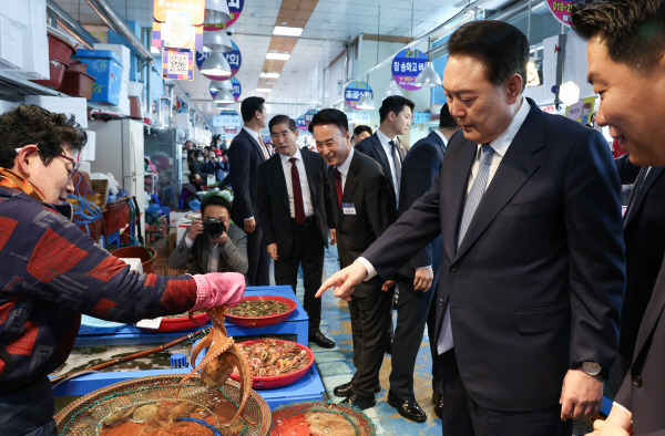 윤석열 대통령이 13일 경남 사천시 삼천포용궁수산시장을 찾아 한 점포에서 문어를 살펴보고 있다. 2024.3.13 연합뉴스