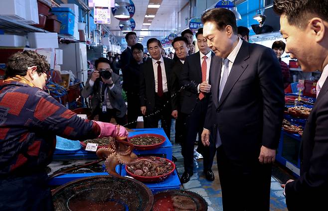 윤석열 대통령이 13일 경남 사천시 삼천포용궁수산시장을 찾아 한 점포를 찾아 문어 등 수산물을 살펴보고 있다. [연합]