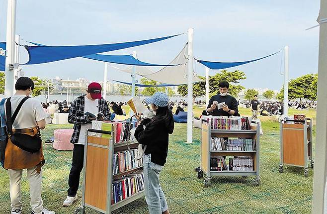 지난 7일 오후 서울 여의도 한강공원에 마련된 야외 도서관을 찾은 시민들이 책을 읽고 있다. /서울시