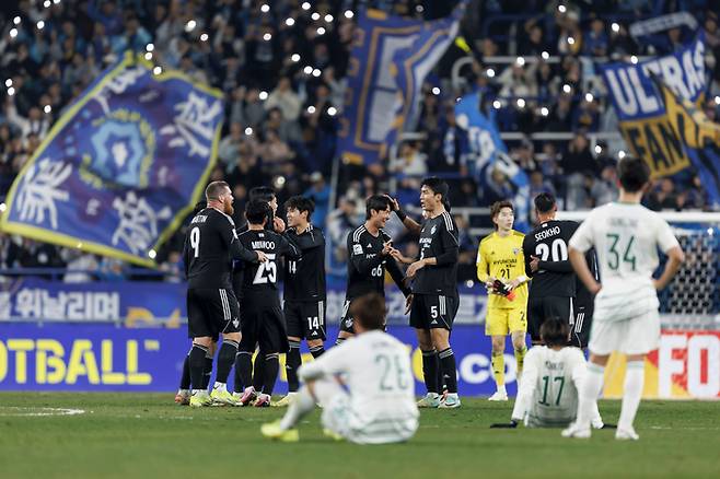 전북 현대 선수들이 12일 울산문수축구경기장에서 열린 울산 HD와의 ACL 8강전 2차전에서 진 뒤 대회 4강 진출을 확정하며 기뻐하는 울산 선수들을 바라보고 있다. 프로축구연맹 제공