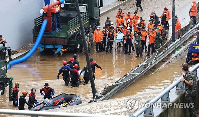 오송 지하차도 추가 실종자 수습 (청주=연합뉴스) 김주형 기자 = 16일 미호천 제방 유실로 침수된 충북 청주시 오송읍 궁평2지하차도에서 119 구조대원들이 시신으로 발견된 실종자를 수습하고 있다.  2023.7.16 kjhpress@yna.co.kr