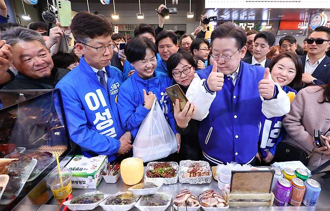이재명 더불어민주당 대표가 지난 15일 부산 부산진구 당감새시장을 방문, 지역 총선 후보들과 족발을 맛보고 엄지를 들어보이고 있다./뉴시스