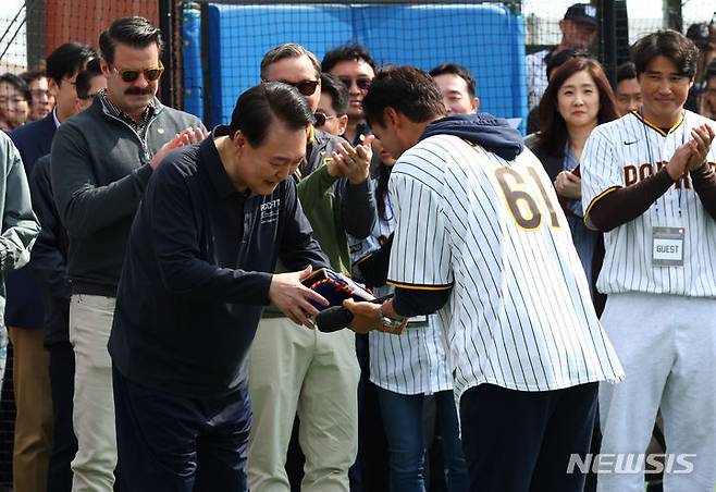 [서울=뉴시스] 전신 기자 = 윤석열 대통령이 16일 서울 용산어린이정원에서 열린 '메이저리거 참여 어린이 야구교실'에서 박찬호 샌디에이고 파드리스 특별 고문으로부터 글러브를 선물 받고 있다. 2024.03.16. photo1006@newsis.com