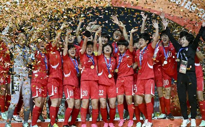 북한 20세 이하 여자축구대표팀이 지난 16일 우즈베키스탄에서 열린 일본과의 2024 아시아축구연맹(AFC) 아시안컵 결승에서 승리한 뒤 우승컵을 들어올리며 기뻐하고 있다. AFC 홈페이지 캡처·연합뉴스