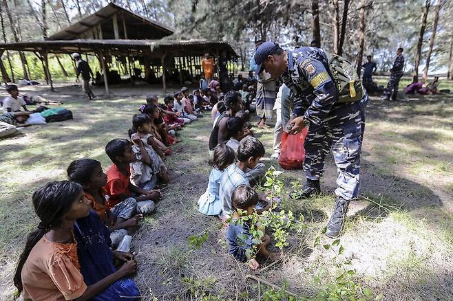 지난달 2일(현지시간) 인도네시아 동아체주 쿠알라 파렉 해변 숲에서 인도네시아 해군이 이곳에 도착한 로힝야족 난민 어린이들에게 음식을 나눠주고 있다. 동아체/EPA 연합뉴스