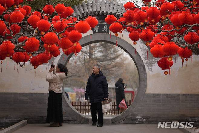 [베이징=AP/뉴시스] ﻿중국의 1~2월 소매판매와 산업생산 등이 예상을 웃도는 호조를 보였다. 사진은 지난 2월 4일 중국 베이징의 지단 공원에서 방문객들이 설날을 앞두고 붉은 등으로 장식된 나무를 스마트폰으로 촬영하는 모습. 2024.03.18