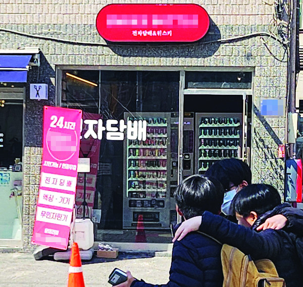 지난 13일 서울 송파구의 한 무인 전자담배판매점 앞을 학생들이 지나가고 있다. 판매점으로부터 30m 지점에 초등학교 정문이 있다.