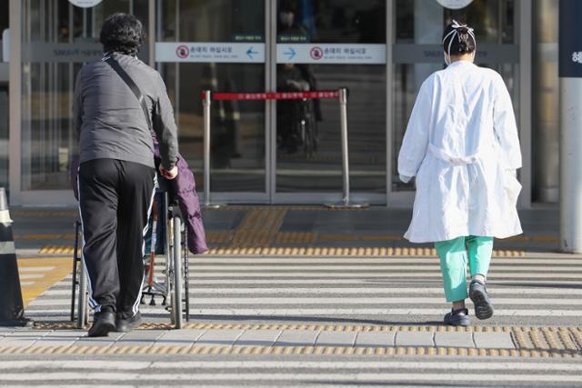 지난 18일 서울의 한 대학병원에서 환자와 의료진이 나란히 길을 건너 병원으로 향하고 있다. 뉴스1