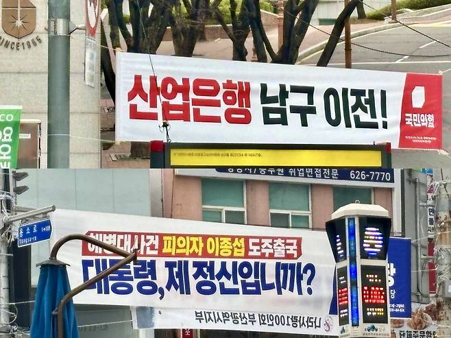 BANNER WARS -- At a busy intersection in Nam-gu, Busan, a banner hung by the People Power Party promotes its pledge to move the Korea Development Bank to Busan. In the image below it, another banner installed by the Democratic Party of Korea nearby reads, “Mr. President, are you out of your mind?” (Kim Arin/The Korea Herald)