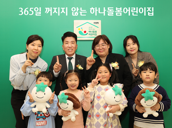 Hana Financial Group Chairman and CEO Ham Young-joo, second from left in the back row, poses for a photo during a launching ceremony for a childcare support program held at a day care center in Nowon District, northern Seoul, on Tuesday. [HANA FINANCIAL GROUP]