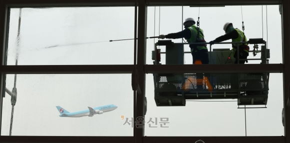 묵은 때 벗고 새단장 나선 인천공항 - 밤낮의 길이가 같은 춘분을 하루 앞둔 19일 오전 인천국제공항 제1여객터미널에서 인천공항운영서비스 직원들이 외부 유리벽에 겨우내 쌓인 먼지를 물로 씻어내고 있다. 이날 밤부터 북서쪽에서 찬 공기가 내려오면서 20일 아침 최저기온은 영하 3도에서 영상 5도, 낮 최고기온은 영상 6∼13도로 평년보다 낮은 기온을 보이겠다고 예보됐다. 도준석 전문기자