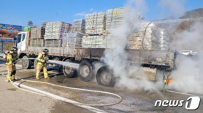 21일 오후 청도군 청도읍 중앙고속도로에서 25톤 화물차의 타이어에서 불이나 소방대원이 진화하고 있다(경북소방본부 제공)2024.3.21/뉴스1