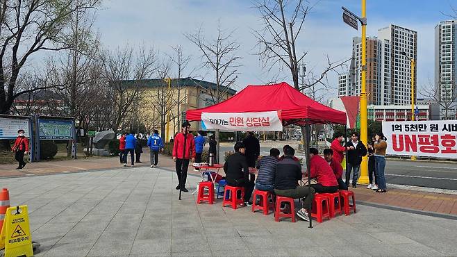 박재호 의원이 박수영 의원의 야외 민원실을 지나치고 있다. 멀리 파란색 점퍼를 입은 사람이 박재호 의원. /박지영 기자
