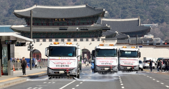 “미세먼지 싹 없애요”… 광화문광장 물청소 - 서울시와 종로구 환경미화 관계자들이 20일 오전 광화문 세종대로에서 살수차로 도로의 미세먼지를 씻어내고 있다. 21일 아침 최저기온은 영하 5도에서 영상 2도, 낮 최고기온은 영상 7∼14도로 예보됐고, 미세먼지 농도는 원활한 대기 확산으로 전국이 ‘좋음’∼‘보통’ 수준을 보이겠다. 연합뉴스