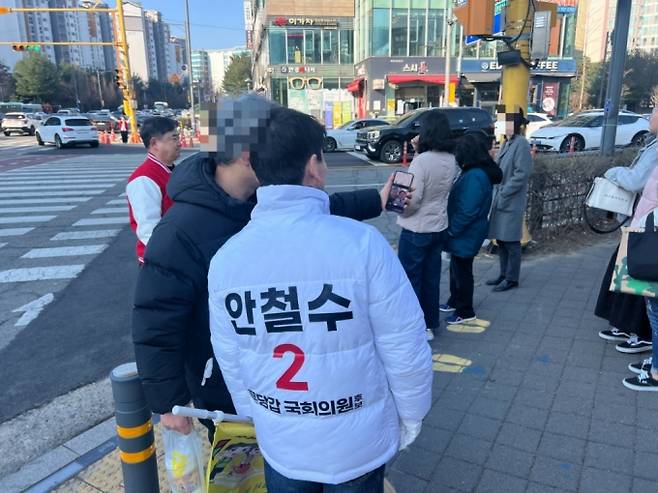 안철수 국민의힘 의원이 20일 오전 성남송현초등학교 사거리에서 교통봉사 중 한 학부모의 사진촬영 요청에 응하고 있다. /사진=박소연 기자