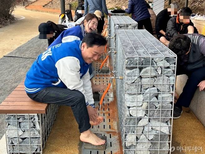더불어민주당 경기 성남분당갑 이광재 후보가 황톳길 걷기 체험을 마치고 발을 씻으면서 주민들과 대화하는 모습 /사진=김도현 기자