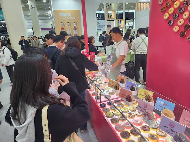 21일 서울 강남구 코엑스 '서울커피엑스포' 흥국에프엔비 부스에서 관람객들이 도넛을 시식 중이다. 정석준 기자