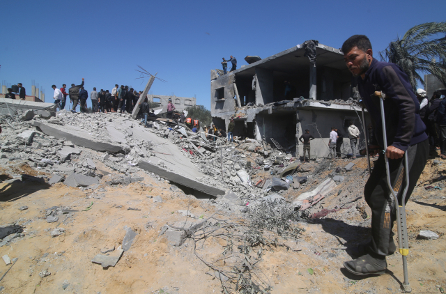 20일(현지시간) 가자지구 남단 라파에서 이스라엘의 공습으로 파괴된 건물을 사람들이 지켜보고 있다. 신화연합뉴스