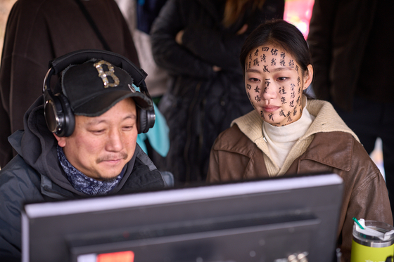 A behind-the-scenes image from ″Exhuma,″ with director Jang Jae-hyun, left, and actor Kim Go-eun [SHOWBOX]