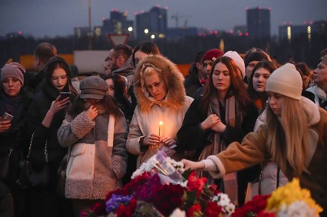 러시아 모스크바 시민들이 23일 테러가 발생한 콘서트홀 근처에 희생자들을 위한 꽃을 바치고 있다. 모스크바/AP 연합뉴스