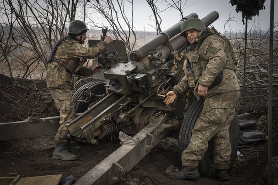 우크라이나 병사들이 지난 22일(현지시간) 우크라이나 도네츠크주 아브디브카 인근 최전선에서 러시아 진지를 향해 M101 곡사포를 발사하고 있다. AP=연합뉴스