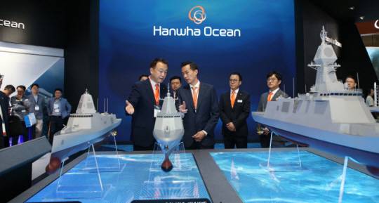 김동관(앞줄 오른쪽) 한화그룹 부회장이 지난 2023년 6월 부산 벡스코에서 열린 ‘MADEX(국제해양방위산업전)’ 당시 한화오션 부스를 방문해 특수선사업부장 이용욱(앞줄 왼쪽) 부사장으로부터 KDDX 관련 설명을 듣고 있다. 연합뉴스