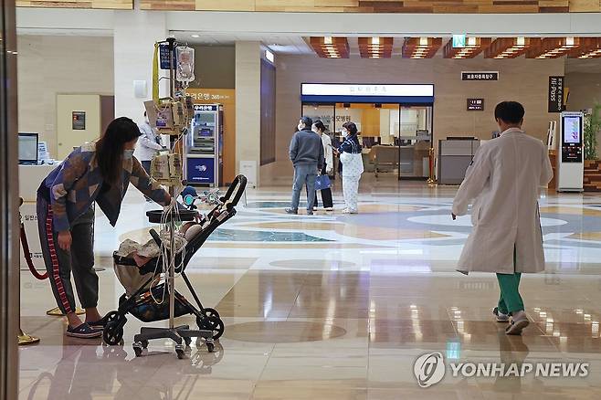 의대 교수마저 환자 곁 떠날까 (서울=연합뉴스) 임화영 기자 = 정부의 의대 정원에 반발한 전국 의대 교수들의 사직서 제출과 전공의 면허정지 처분을 하루 앞둔 24일 서울 시내의 한 대학병원에서 한 소아환자 옆으로 의료진이 지나가고 있다.
    전국 의대 교수 비상대책위원회는 25일부터 19개 대학별로 사직서를 제출하기로 결의했으며, 보건복지부는 업무개시명령에도 돌아오지 않은 전공의들의 면허를 내일부터 차례로 정지시킬 계획이다. 2024.3.24 hwayoung7@yna.co.kr