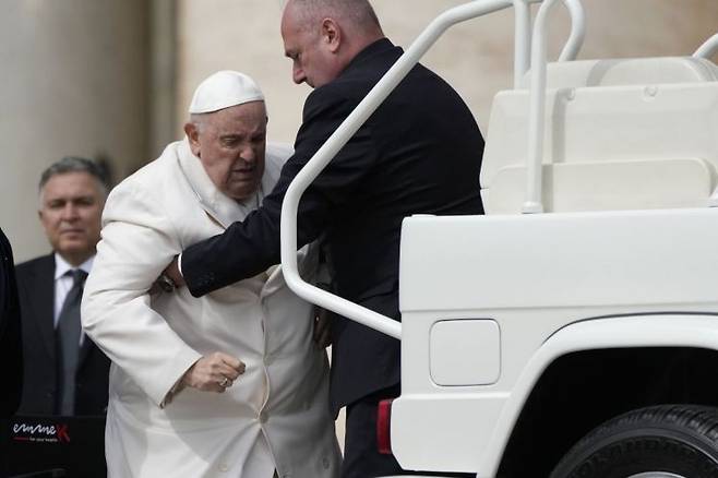 프란치스코 교황(가운데)이 지난해 3월29일(현지시간) 바티칸 성 베드로 광장에서 열린 수요 일반 알현 후에 부축을 받으며 차량에 오르고 있다. [사진=바티칸 AP/연합뉴스]