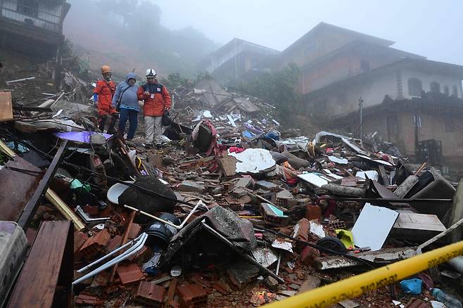 23일(현지시간) 브라질 페트로폴리스에서 민방위 대원들이 폭우 현장에서 구조활동을 벌이고 있다. AFP=연합뉴스