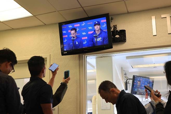 LA다저스 오타니 쇼헤이가 26일(한국시간)  다저스 스타디움 프레스 박스에서 TV를 통해 보이는 비공개 기자회견에서 성명을 발표하고 있다. 사진 | AFP연합뉴스