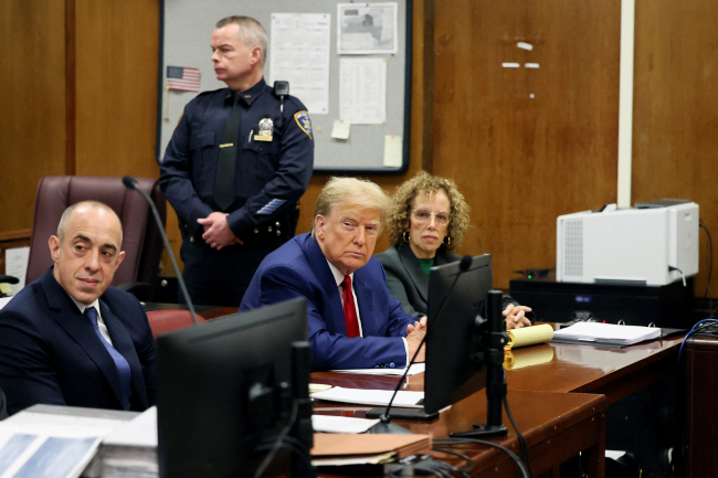 도널드 트럼프(가운데) 전 미국 대통령이 25일 뉴욕 맨해튼 형사법원에서 열린 성추문 입막음 의혹 사건 공판에 출석해 앉아 있다.    로이터 연합뉴스