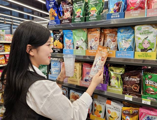 모델이 편의점 CU에서 올해 출시된 대용량 파우치 음료 '델라페'를 살펴보고 있다. 사진제공=BGF리테일