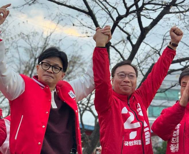 한동훈 국민의힘 비상대책위원장 겸 총괄선거대책위원장이 26일 오후 부산 신평역 앞에서 정연욱 수영구 후보의 손을 번쩍 들어 올리며 시민들께 지지를 호소하고 있다. ⓒ정연욱 후보 캠프