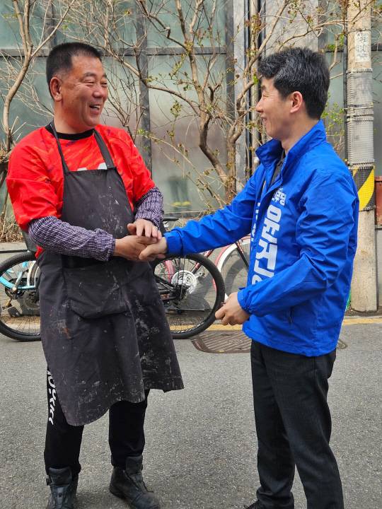 윤건영 더불어민주당 서울 구로을 후보가 27일 골목길에서 만난 시민과 인사를 나누고 있다.<운건영 후보 캠프 제공>