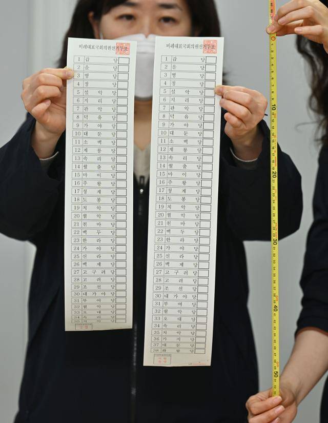 26일 서울 종로구 서울특별시선거관리위원회에서 선관위 관계자가 제22대 국회의원 선거 비례대표 모의 투표용지를 지난 총선 투표용지와 비교해 길이를 측정하고 있다. 최주연 기자