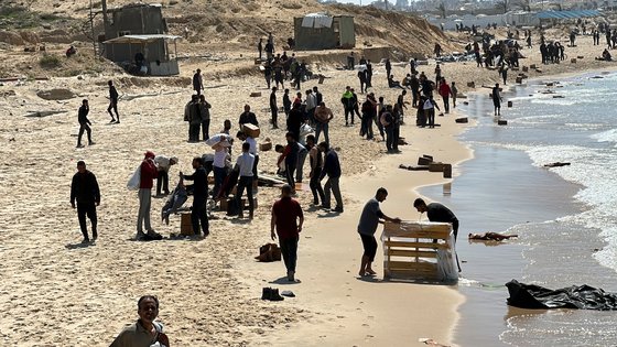 팔레스타인 사람들이 25일 해안에 몰려들어 구호품을 확보하고 있다. 로이터=연합뉴스