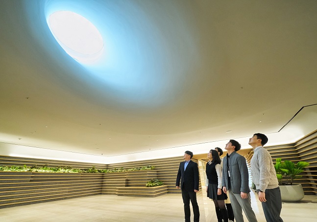 LG 직원들이 LG트윈타워 지하 1층에 새로 조성된 '틴들(Tyndall)'에서 햇빛이 들어오는 천장을 바라보고 있다./사진=LG 제공