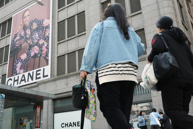 27일 오전 시민들이 서울의 한 백화점에 입점한 프랑스 명품 브랜드 샤넬 매장의 쇼윈도 앞을 지나고 있다. 뉴스1