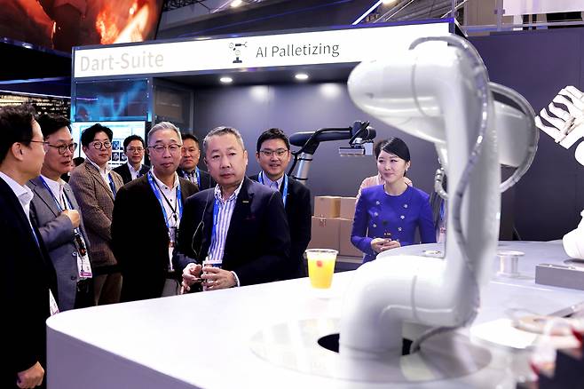 박정원(가운데) 두산그룹 회장이 지난 1월 CES 2024 현장에서 두산의 인공지능(AI) 칵테일 로봇을 살펴보는 모습. 박 회장 뒤에는 박지원 두산그룹 부회장 [두산 제공]