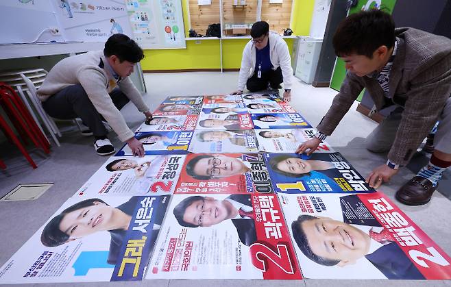 제22대 국회의원선거 선거벽보 제출 마감일인 27일 부산시선거관리위원회에서 선관위 관계자들이 부산 지역 후보 선거 벽보를 정리하고 있다. 연합뉴스