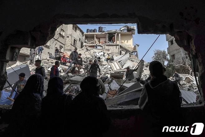 27일(현지시간) 가자지구 라파에서 주민들이 이스라엘의 공격으로 와르르 무너진 주택 잔해를 바라보고 있다. 2024.03.27/ ⓒ AFP=뉴스1 ⓒ News1 권진영 기자