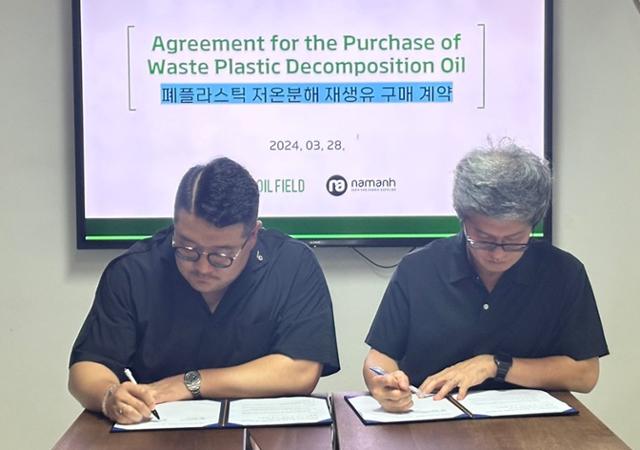 ㈜도시유전 정영훈 대표(왼쪽)와 남안JSC 방비엔통 대표가 베트남 호치민시 남안JSC 본사에서 열린 '폐플라스틱 분해유 구매(수출)계약' 체결식에서 서명을 하고 있다.