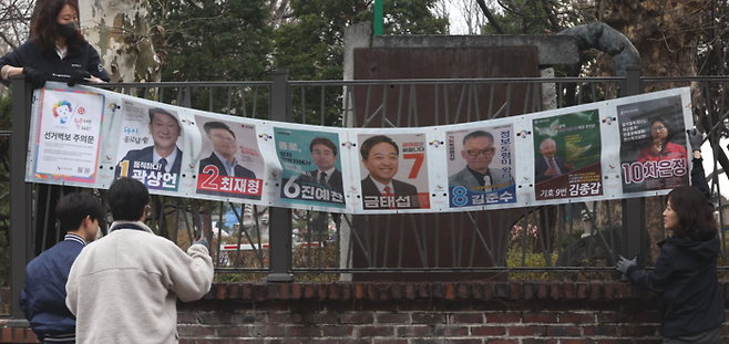28일 오전 서울 종로구 동숭동 예술가의집에서 서울시선거관리위원회 관계자들이 제22대 국회의원선거 종로구 후보자 선거벽보를 붙이고 있다. 2024.3.28  [이승환 기자]