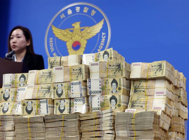 지난 26일 서울 마포구 서울경찰청 금융범죄수사대에 쌓여있는 41억여 원의 범죄수익 현금다발 뒤로 김미애 금융범죄수사대 계장이 브리핑을 하고 있다. 연합뉴스
